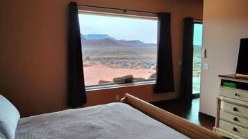 Un dormitorio con un ventanal que ofrece vistas al paisaje desértico.