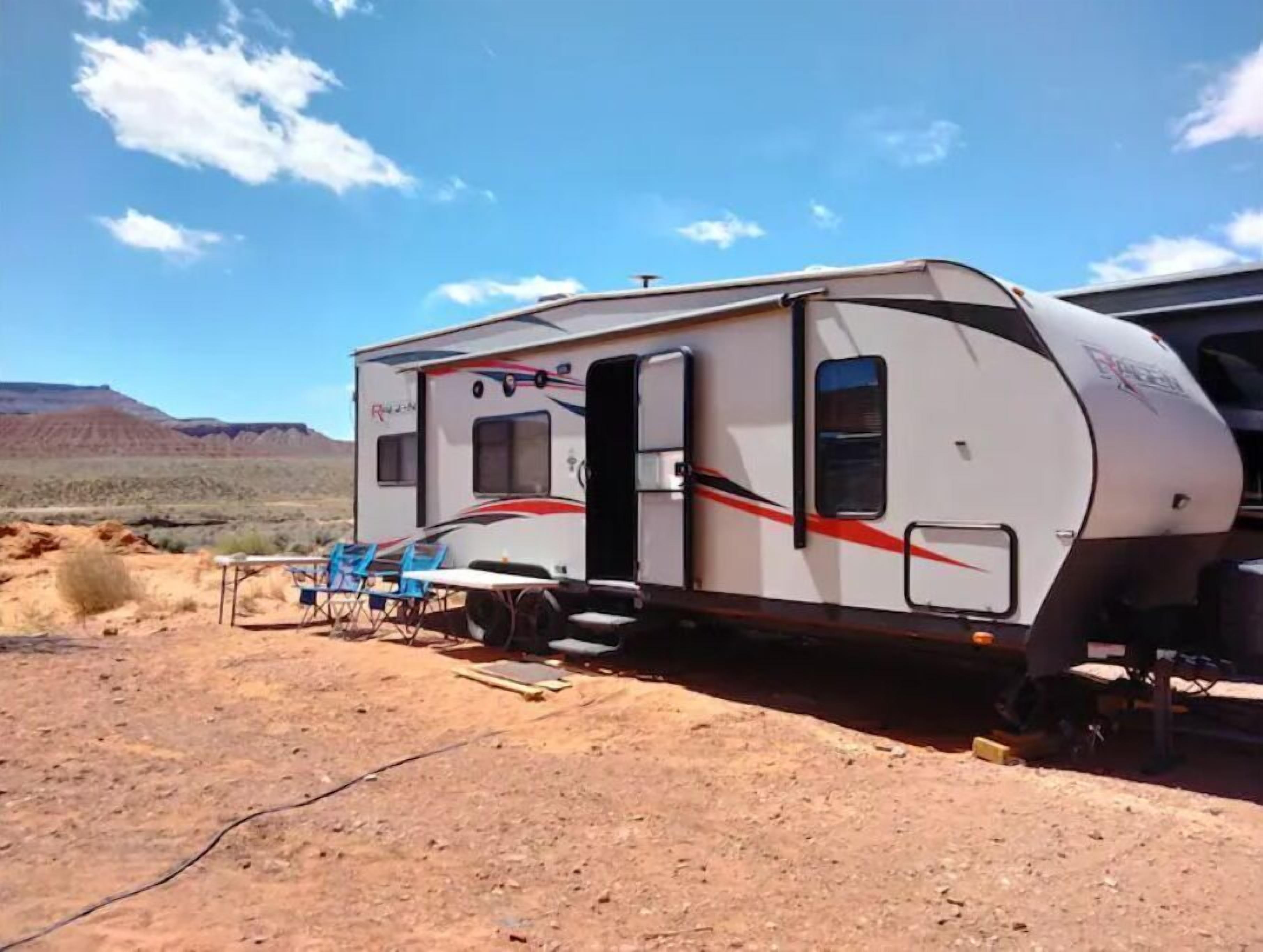 Una caravana estacionada en un desierto bajo un cielo despejado.