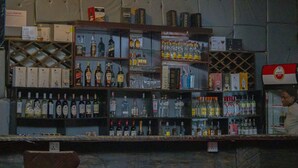 A bar with shelves stocked with various liquor bottles and glasses. - Quinta Nova Hotel (Kigali)