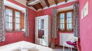 A bedroom with a bed, a wardrobe, a chair, and a radiator. - Apartment in Abetone with 2 bedrooms sleeps 4 (Abetone)