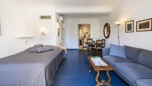 A bedroom with a bed, a sofa, a coffee table, and a dining area with chairs and a table. - Serragli Retreat in Florence by Mmega (Firenze)