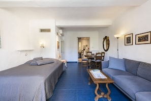 A bedroom with a bed, a sofa, a coffee table, and a dining area with chairs and a table. - Serragli Retreat in Florence by Mmega (Firenze)