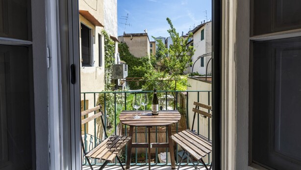 A balcony with a table, chairs, and a bottle of wine. - Serragli Retreat in Florence by Mmega (Firenze)