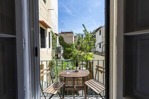 A balcony with a table, chairs, and a bottle of wine. - Serragli Retreat in Florence by Mmega (Firenze)