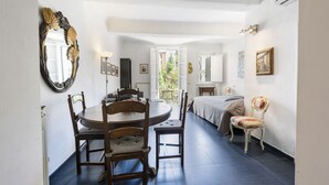 A room with a dining table, chairs, a bed, a mirror, and a window. - Serragli Retreat in Florence by Mmega (Firenze)