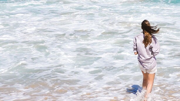 A person walking on a sandy beach with waves. - Vila Carijós (Florianópolis)