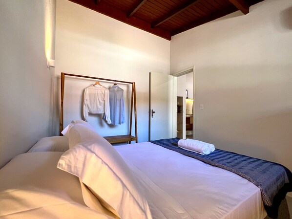 A hotel room with a bed, a wardrobe, and a mirror.