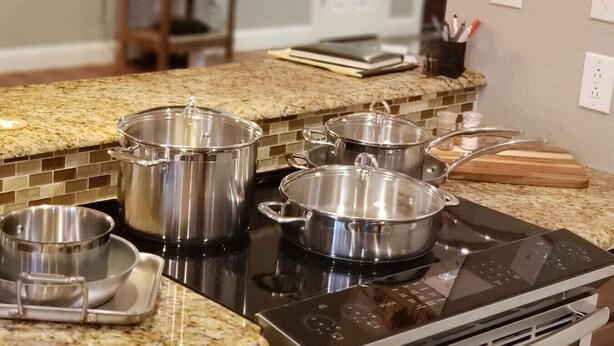A kitchen with a granite countertop, stainless steel pots, and a black induction cooktop. - Wildcatter resting grounds, spacious living (Odessa)