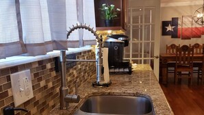 A kitchen with a double sink, a coffee machine, and a grill. - Wildcatter resting grounds, spacious living (Odessa)