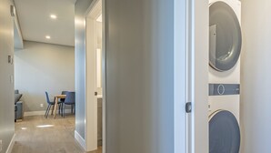 Un appartement moderne comprenant un coin repas, une buanderie et un couloir.