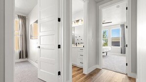Ein Flur mit weißen Türen zu einem Badezimmer und einem Schlafzimmer.