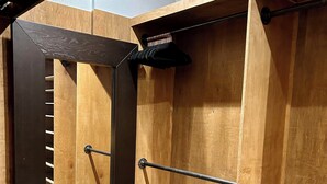 Une pièce compacte dotée d’une armoire à portes miroir, d’une étagère coulissante et d’une tringle rétractable.