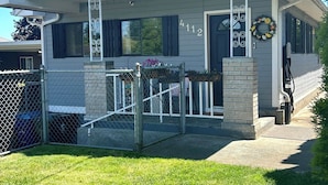 Une maison à deux étages avec un porche couvert, un garage et une cour clôturée.