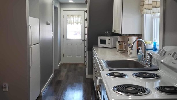 A modern kitchen with a stove, microwave, and sink.