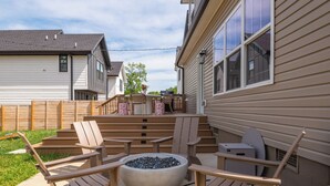 A backyard with outdoor furniture, a fire pit, and a deck. - Large 4BR Home Near Broadway with Hot Tub and Private Backyard (Nashville)
