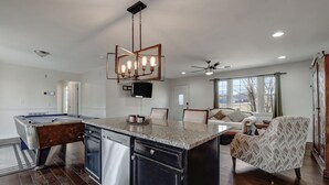 A modern kitchen with a central island, built-in appliances, and a ceiling fan.