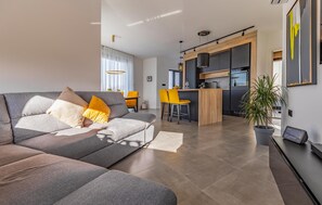 Relax in this stylish living area with a sofa, dining space, and kitchenette.
