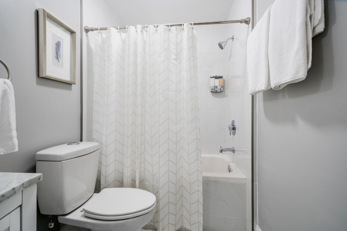 Une salle de bain équipée de toilettes, d’une douche et d’une baignoire.