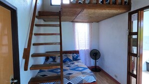 A room with a bunk bed, a wooden staircase, a fan, and a door. - Pamana Beach House  (Calatagan)