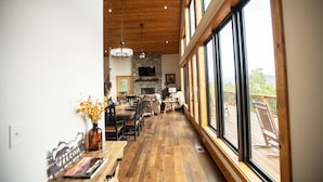 Un comedor amplio con una larga mesa de madera, varias sillas y un gran ventanal con vistas al exterior.