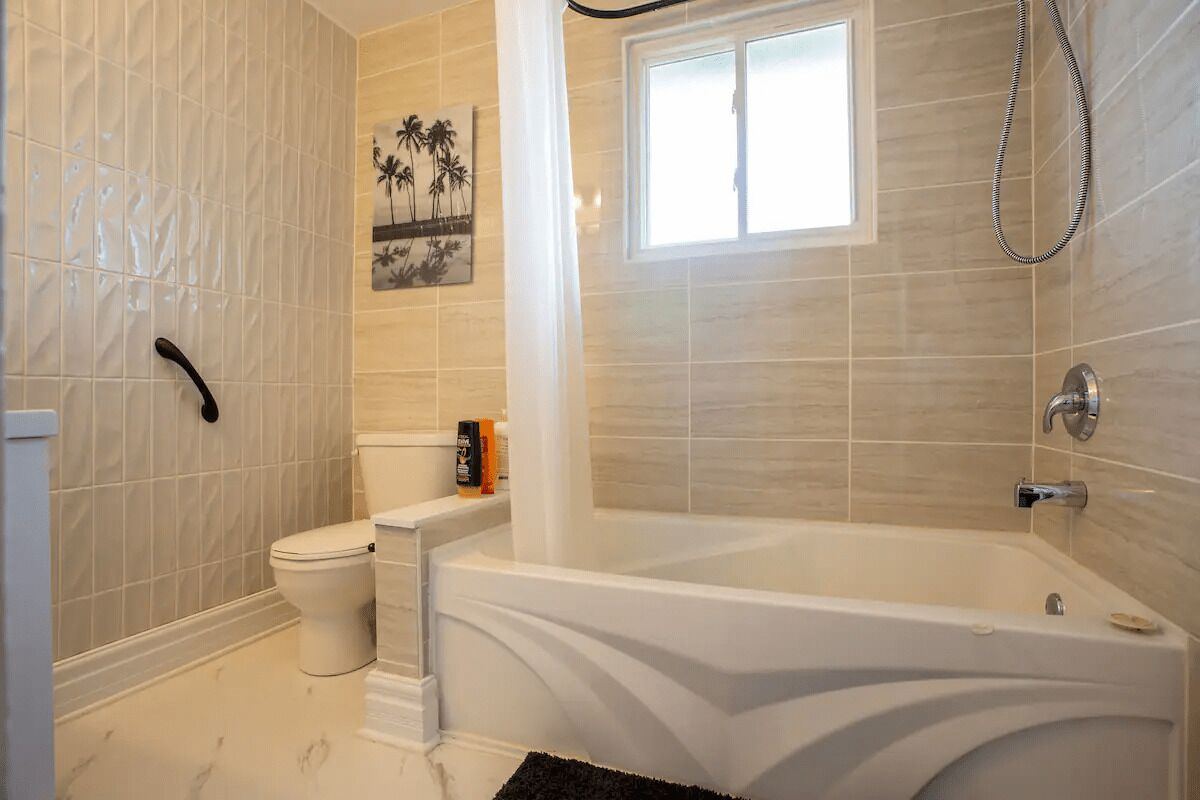 A bathroom with a bathtub, toilet, and shower.