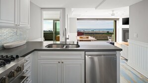A modern kitchen with a view of the beach. - Oceanfront | Private Ground Floor Patio | Hot Tub (San Diego)
