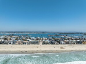 A coastal cityscape with a beach, marina, and residential buildings. - Oceanfront | Private Ground Floor Patio | Hot Tub (San Diego)