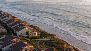 Un quartier résidentiel situé sur la côte, avec des maisons donnant directement sur la plage.