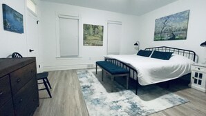 A bedroom with a bed, a bench, a dresser, and a nightstand. - Private Vacation Home with large Hot Tub and Fire Pit -- Sleeps 18 (Gibsonia)