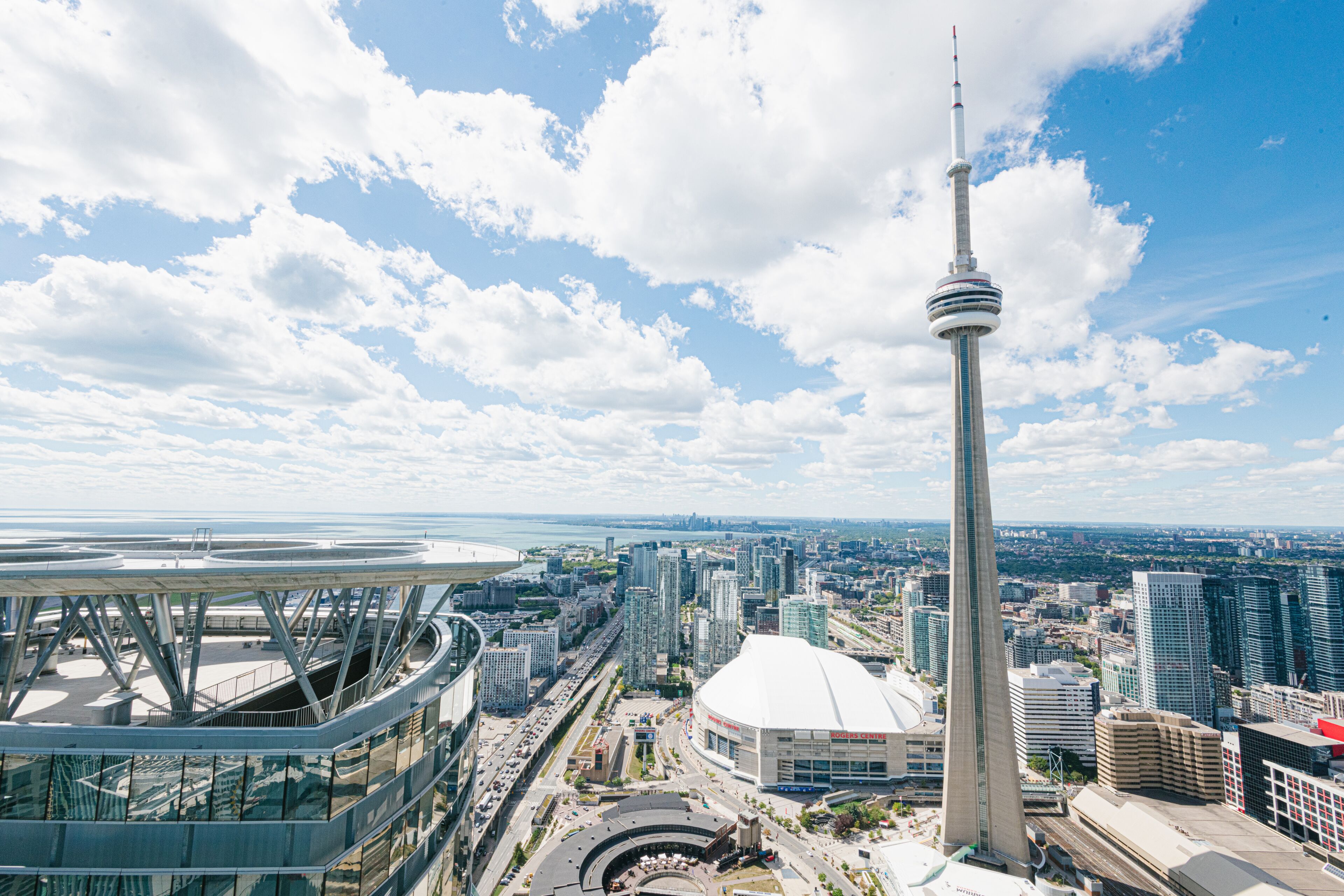 A cityscape with a prominent tower, modern buildings, and a stadium.