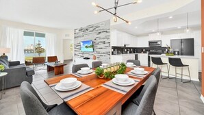 A modern apartment with a dining area, kitchen, and living room.