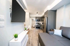 A modern apartment with a living area, a kitchenette, and a dining space. - Cozy condo sleeps 4  (Niagara Falls)