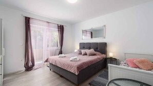 A bedroom with a bed, bedside table, and a mirror on the wall. - Villa with pool, air conditioning, internet and covered terrace, near the sea (Umag)