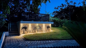 A well-lit entrance sign for Villa Royale with palm tree motifs and a crest. - Villa Royale Luxury 4-bedroom Paradise In Sosua (Sosúa)