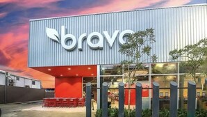 Un bâtiment moderne, orné d’une grande enseigne portant le mot « bravo », avec une base rouge et une partie supérieure métallique.