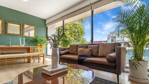 Un salon moderne avec un canapé, une table basse et une vue sur l’extérieur.