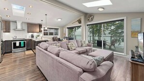 Ein modernes Wohnzimmer mit Ecksofa, Essbereich und Küche.