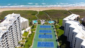 A high-rise hotel with a rooftop tennis court, a swimming pool, and a beach view. - Luxury beachfront condo with the best ocean view! (South Padre Island)