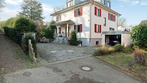 Ein zweistöckiges Haus mit gepflasterter Auffahrt und Garage.