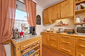 A kitchen with wooden cabinets, a coffee maker, a toaster, and a microwave. - Apartment 'Feldbergblick' with Private Terrace, Balcony and Wi-Fi (St. Märgen)