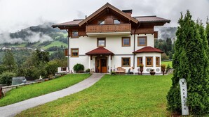Ein zweistöckiges Haus mit einem Balkon, einer Haustür und einem Weg zum Eingang.