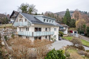 Een twee verdiepingen tellend huis met een balkon, een garage en een oprit.