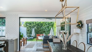 Una cocina moderna con comedor, vistas al jardín trasero y un ventilador de techo.