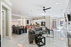 A spacious living area with a modern kitchen, a dining area, and a seating area with a sofa and chairs.