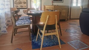 A dining area with a wooden table, chairs, and a patterned rug. There are framed artworks on the walls and a window with a view of the outdoors. - Make memories in this artists quarters.
Blue mosaic place - start to explore HB. (Waimarama)