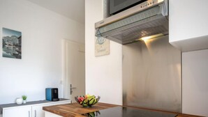 A modern kitchen with a wooden countertop, stainless steel appliances, and a small plant. - Beau séjour 15 by Interhome (Ovronnaz)