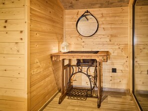 Cozy room with wooden paneling, a small mirror, and a wooden table featuring a lantern.