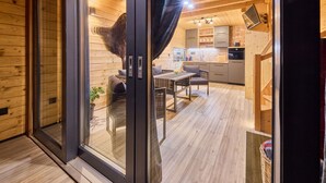 A modern interior with a dining area, kitchen, and wooden walls.