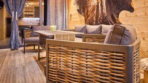 A cozy interior with a sofa, a table, and a wall-mounted light fixture.