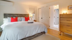 A bedroom with a bed, a dresser, and a door leading to another room. - 1 Mi to Sand! Mid-Cape Chatham w/ Furnished Deck (Chatham)